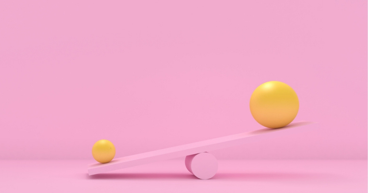 Yellow balls balancing on pink seesaw