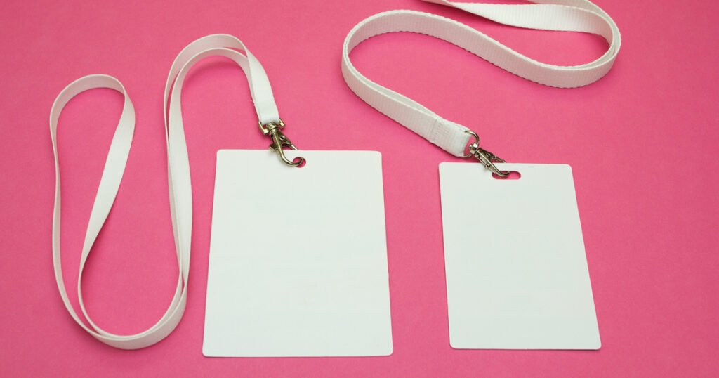 Two blank white lanyards on pink background