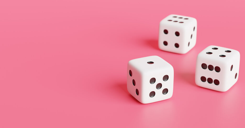 Three dice on pink background.
