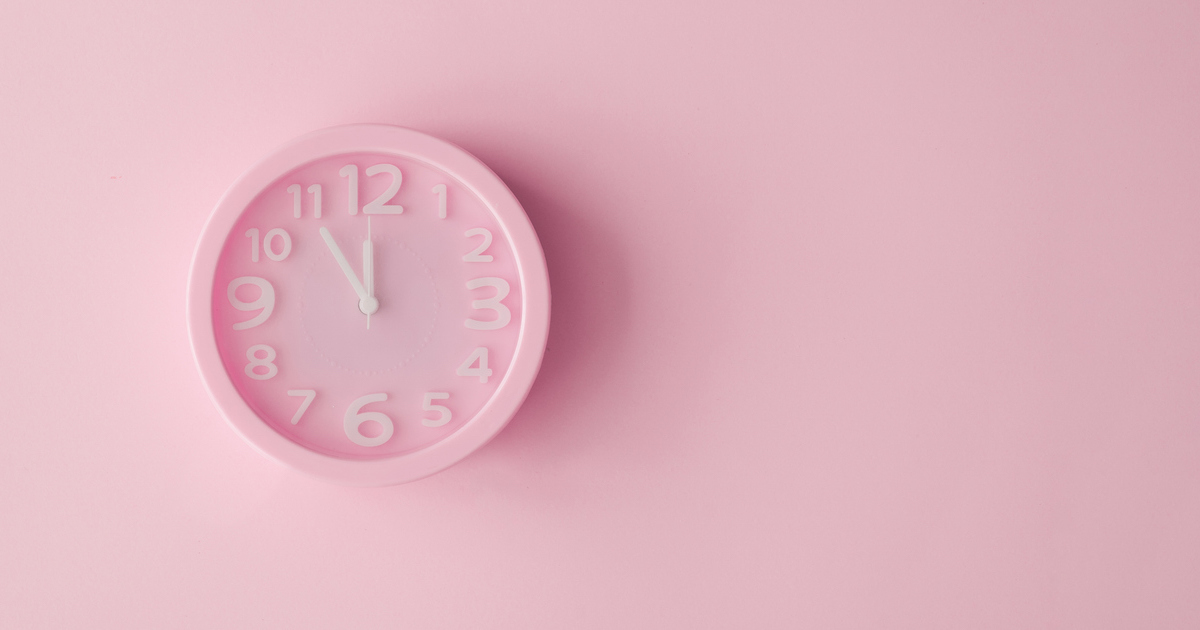 Pink clock on pink background showing 10:10