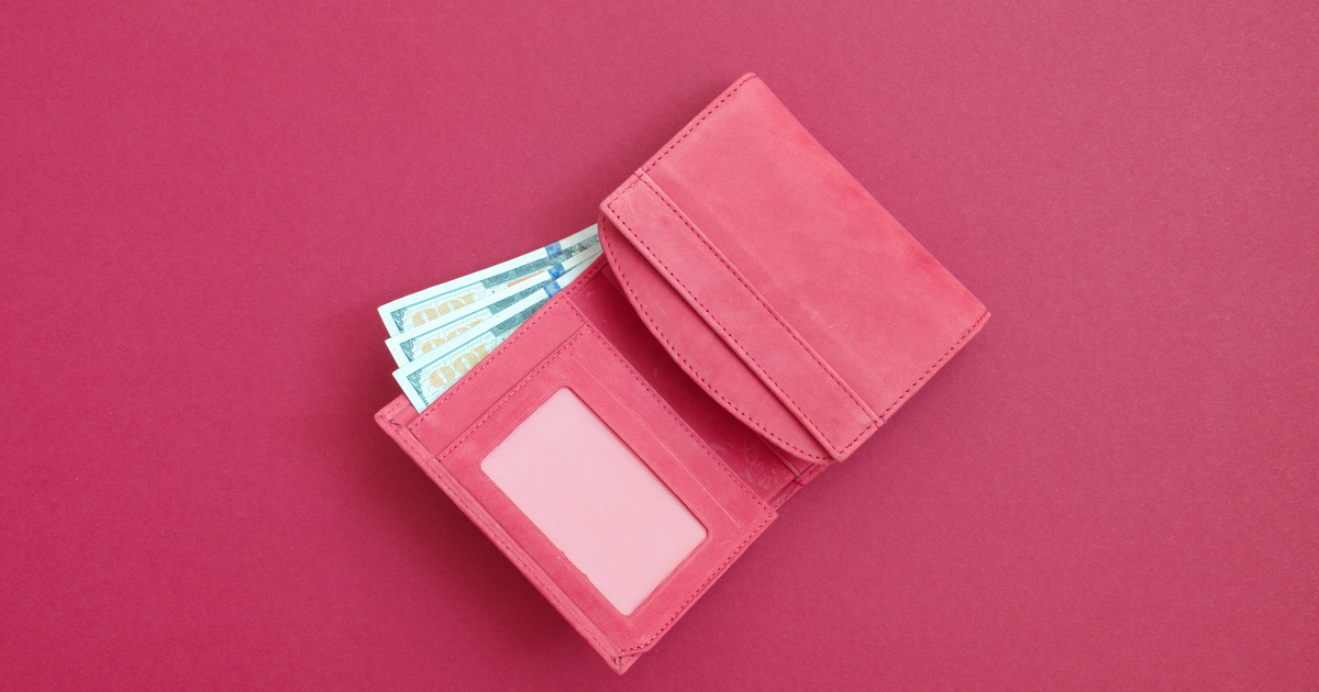 Open pink wallet with cash on red background
