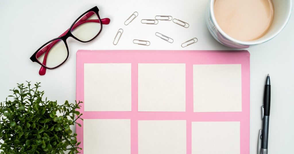 Organized desktop with planner, glasses, and coffee.