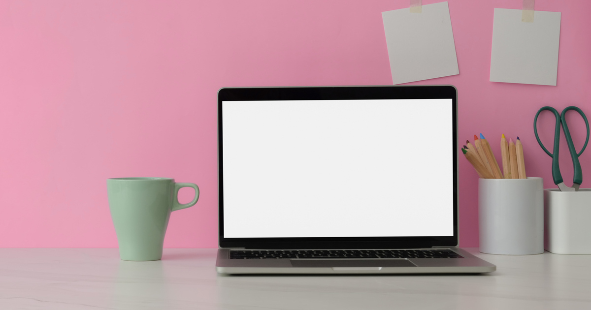 Laptop on desk with pink background
