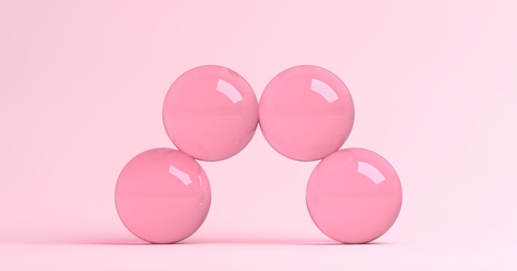 Pink glossy spheres arranged in arch formation.