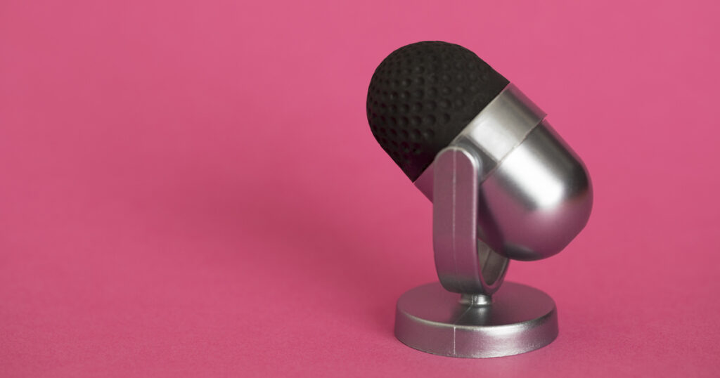 Silver microphone on pink background