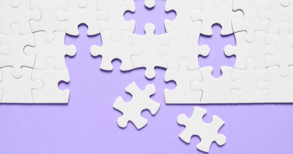 White puzzle pieces on purple background