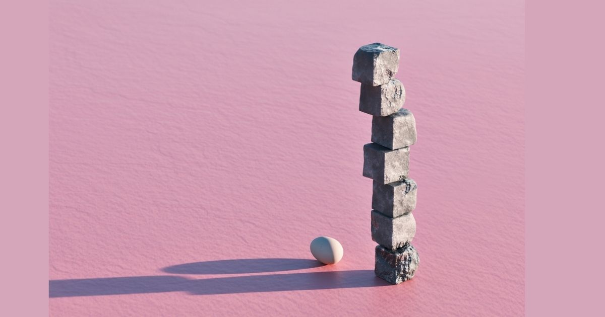 Stacked cubes and egg on pink background