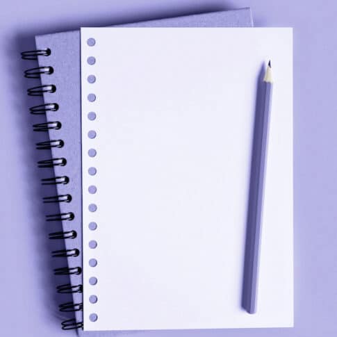 Lavender notebook and pencil on top of lavender background