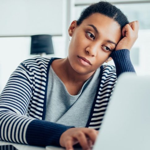 stressed businesswoman working tirelessly on laptop