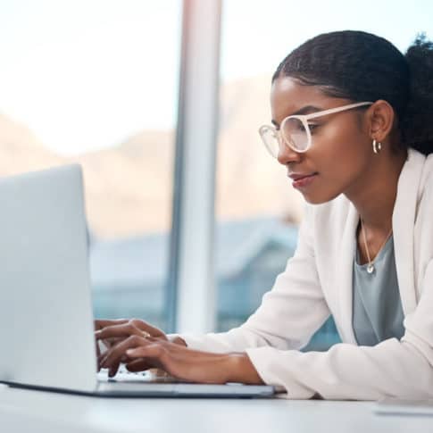 young businesswoman very focused while working from a laptop at her desk in a modern office
