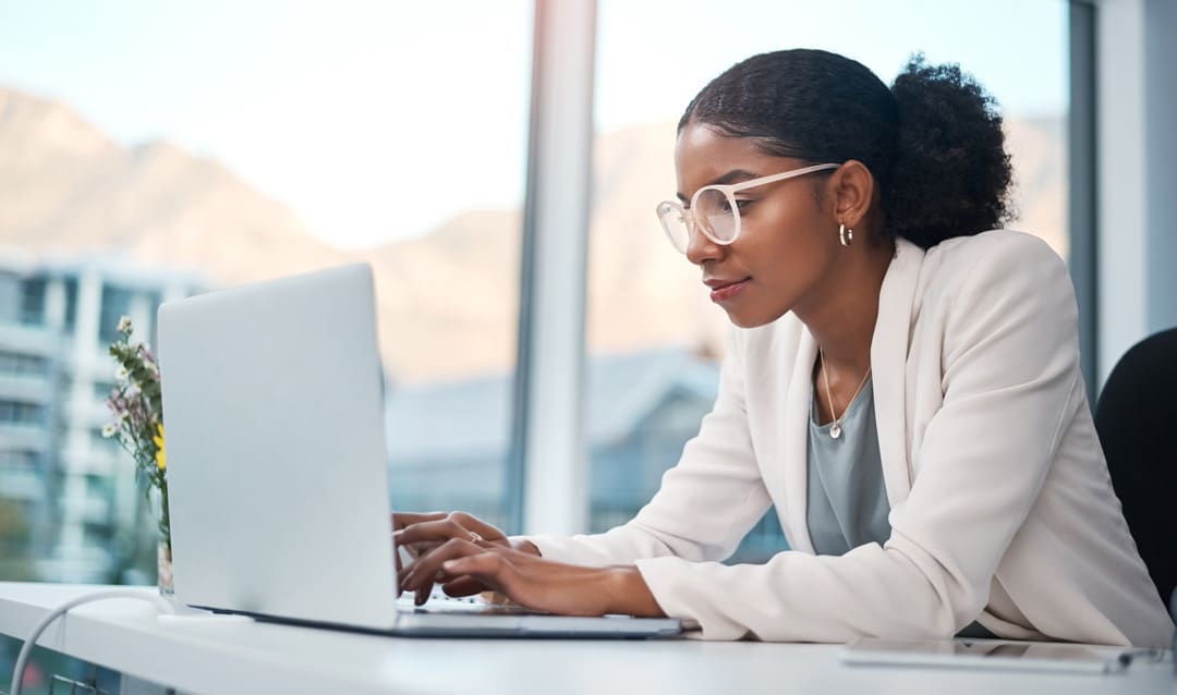 young businesswoman very focused while working from a laptop at her desk in a modern office