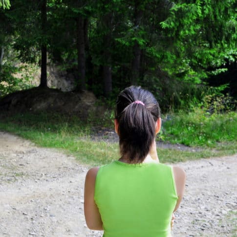 Woman looking at a forked road