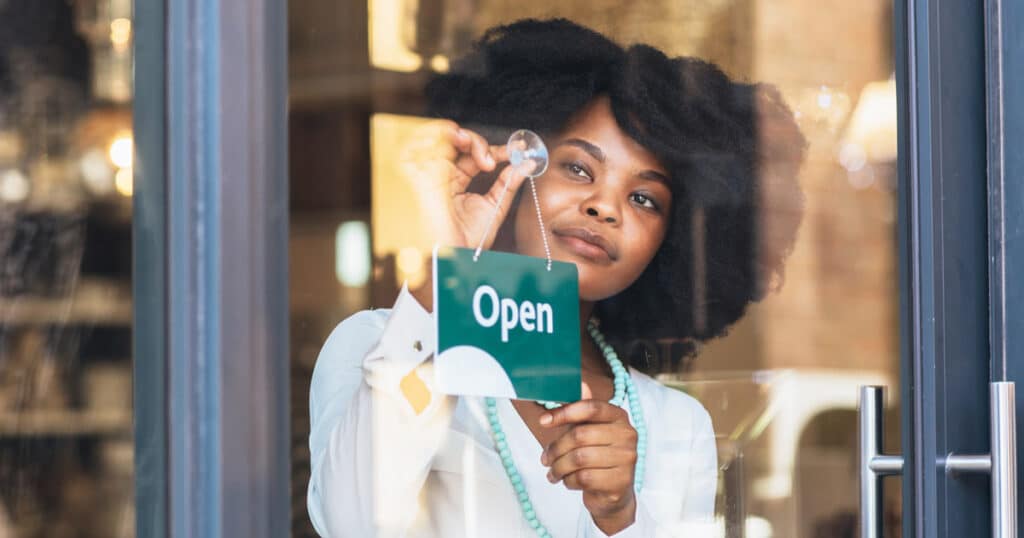 black business owner hanging open sign