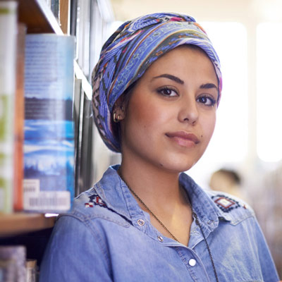 middle eastern woman in library aisle