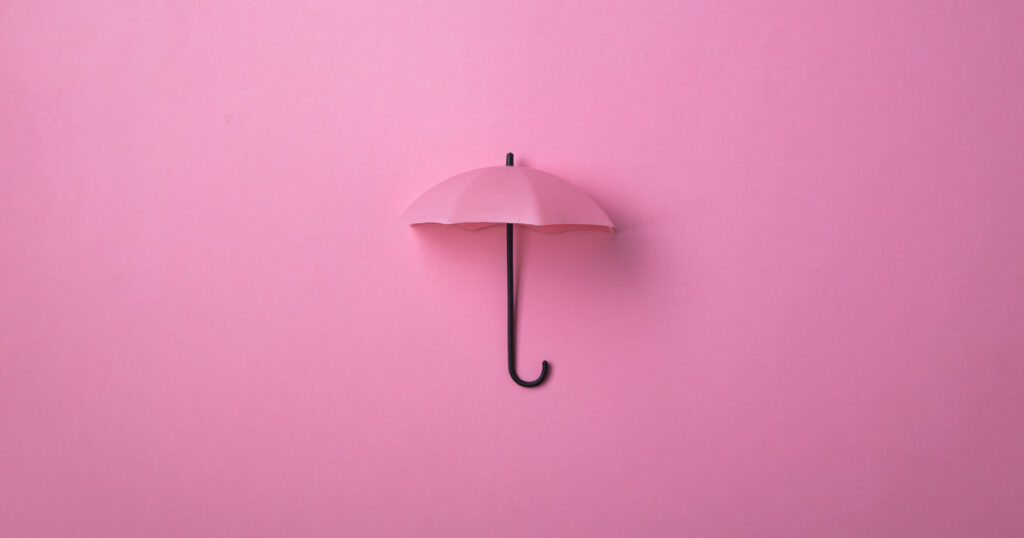 Pink umbrella on pink background