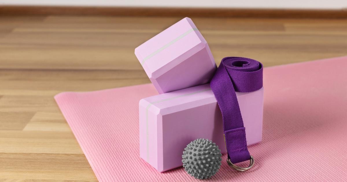 Yoga blocks, strap, ball on pink mat