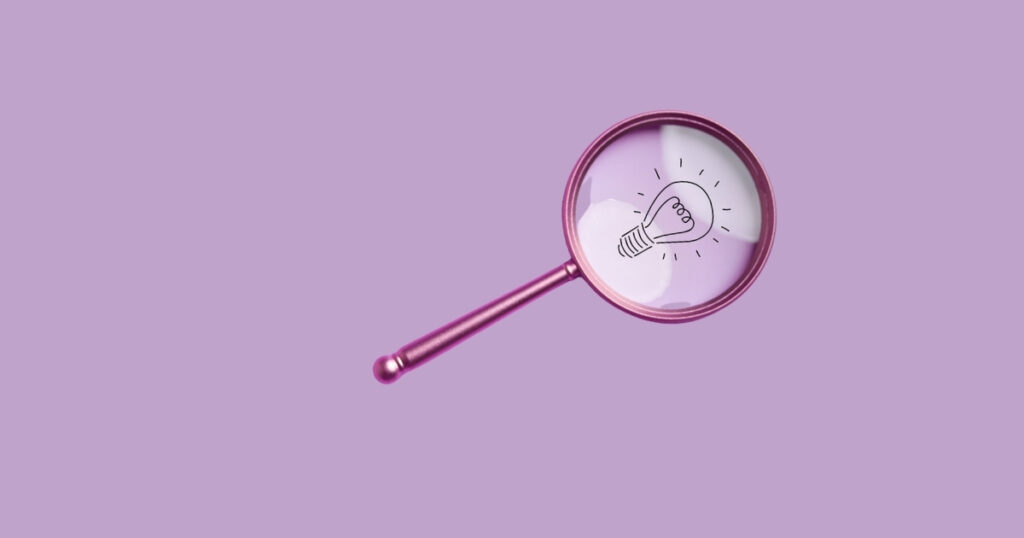 Magnifying glass over light bulb illustration.