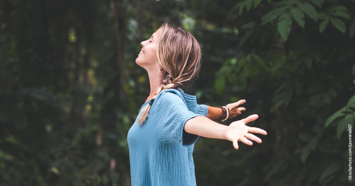 woman connecting with nature while releasing limiting beliefs