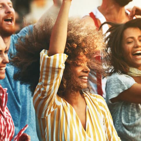 women happily dancing at concert