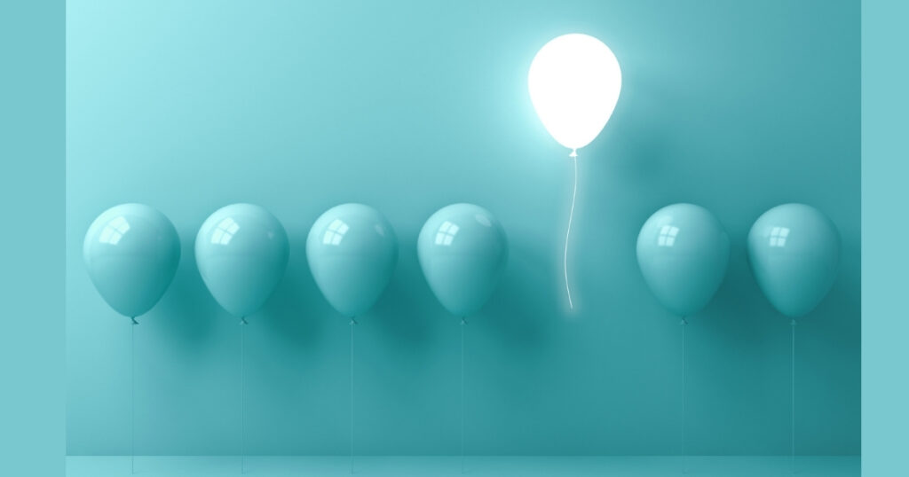 Glowing white balloon among blue balloons.
