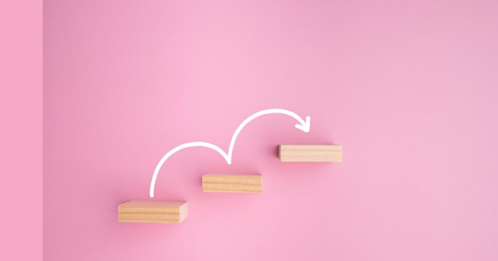 Wood blocks on pink background with arrow