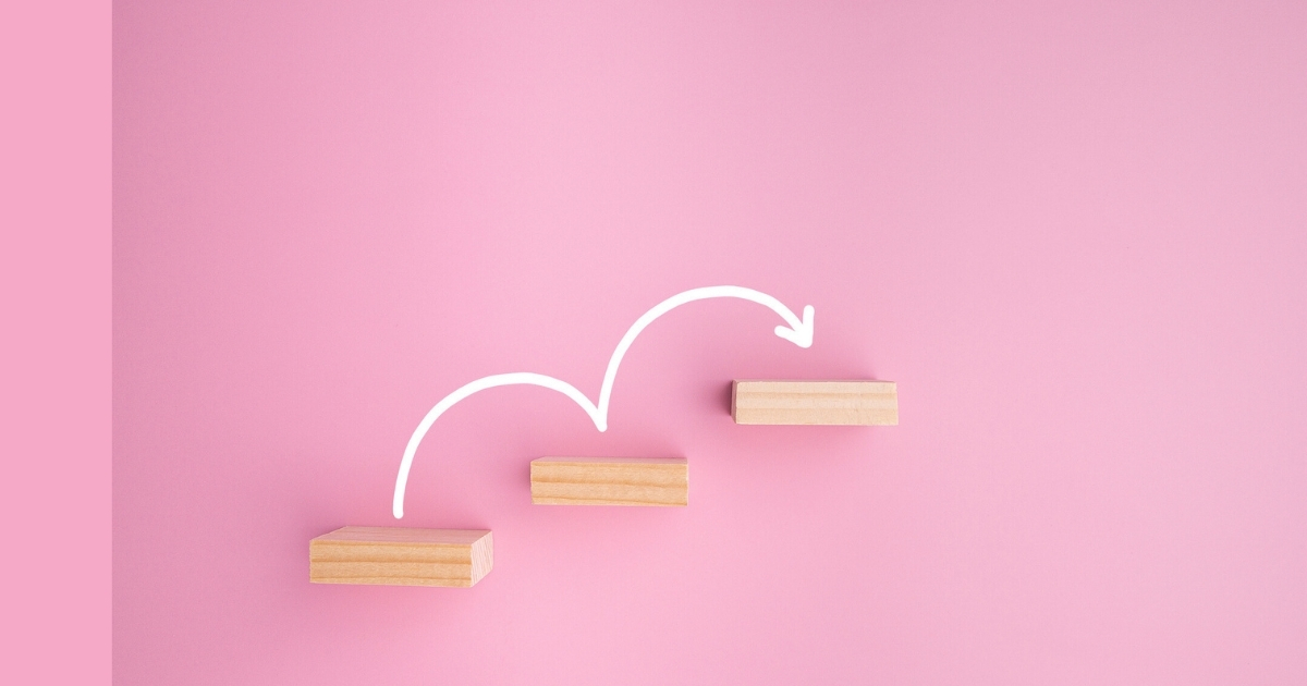 Wood blocks on pink background with arrow