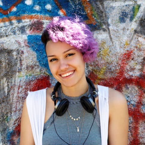 vibrant female hipster against graffiti wall