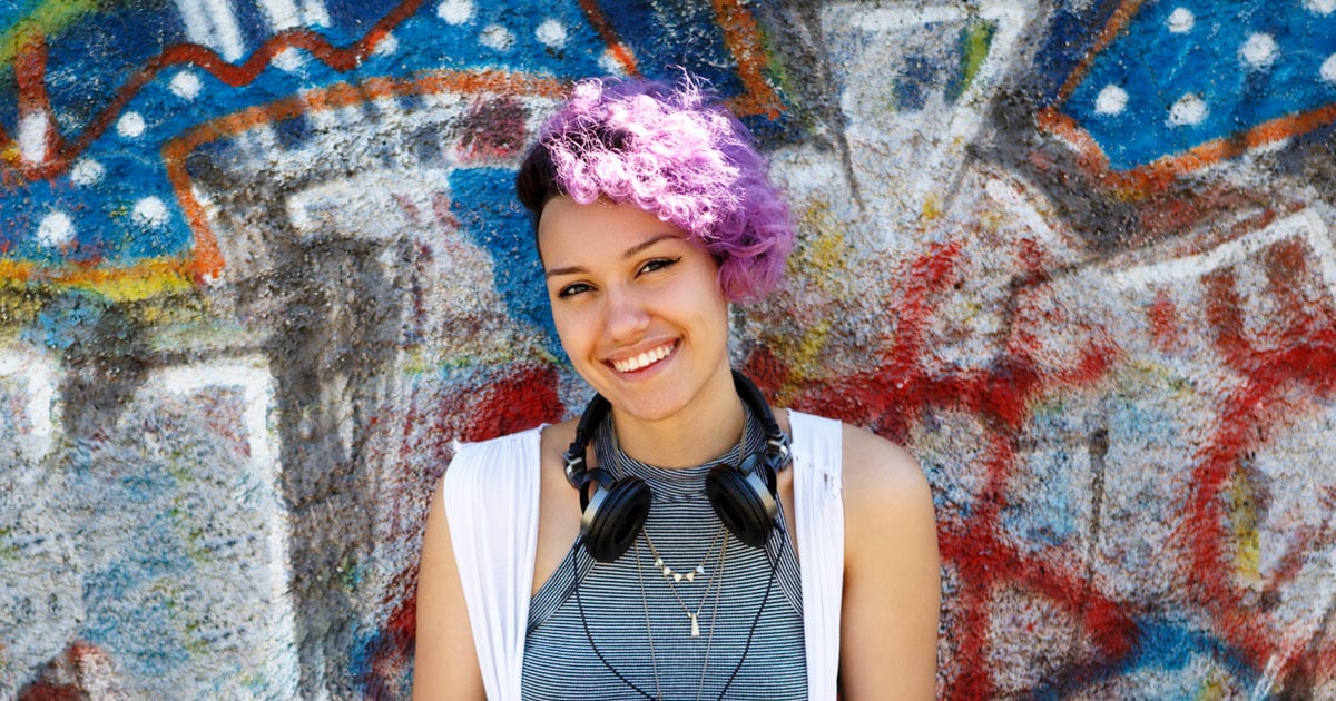 vibrant female hipster against graffiti wall