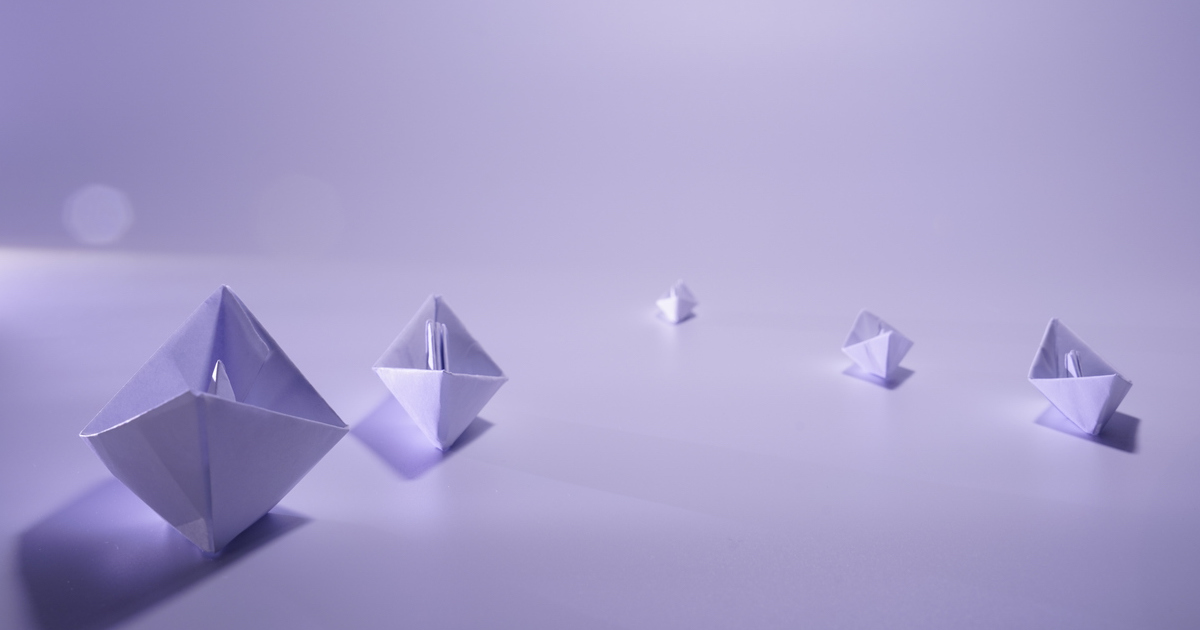 Purple origami boats on smooth surface.