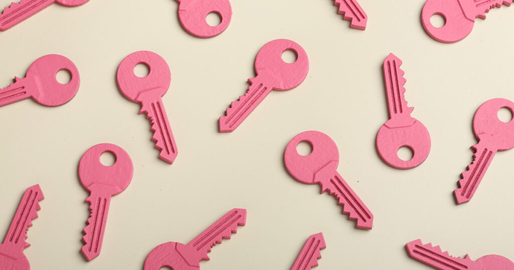 Multiple pink keys arranged on beige background.