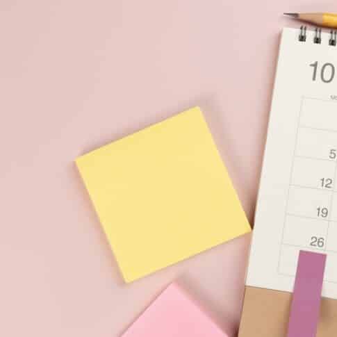 close up of calendar on the colorful pink table background, planning for business meeting or travel planning concept