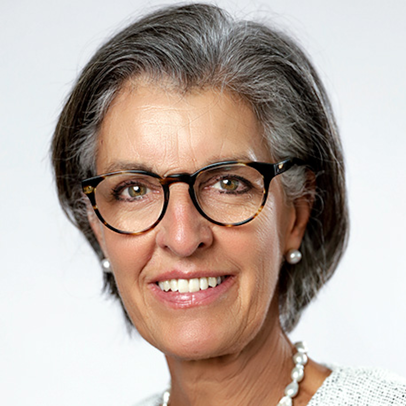 Smiling older woman wearing glasses and pearls