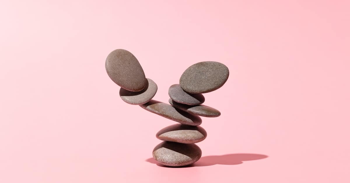 Concept of balance of gray stones on a pink background
