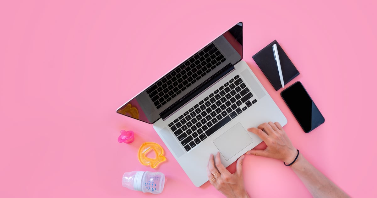 Working mom top view flatlay of workplace baby items and laptop with phone; work family concept