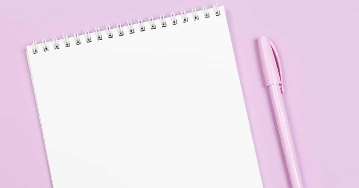 Notebook with blank page and pen on a violet pastel background. Flat lay. Place for text.