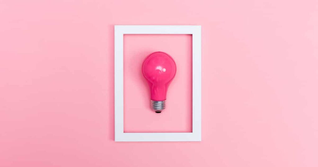 Colored lightbulb on a pink background with frame
