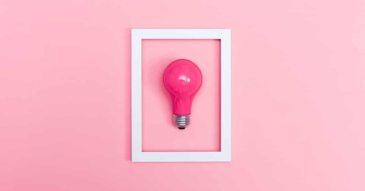 Colored lightbulb on a pink background with frame