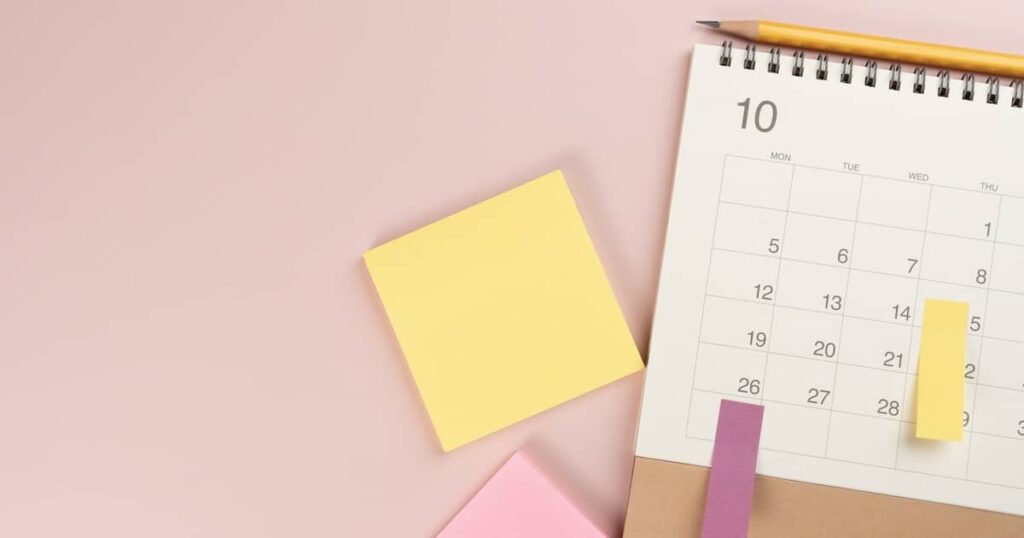 close up of calendar on the colorful pink table background, planning for business meeting or travel planning concept
