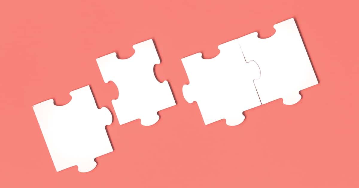 Jigsaw puzzle matching pieces. Teamwork and solution or idea concept with copy space on trendy pastel living coral background
