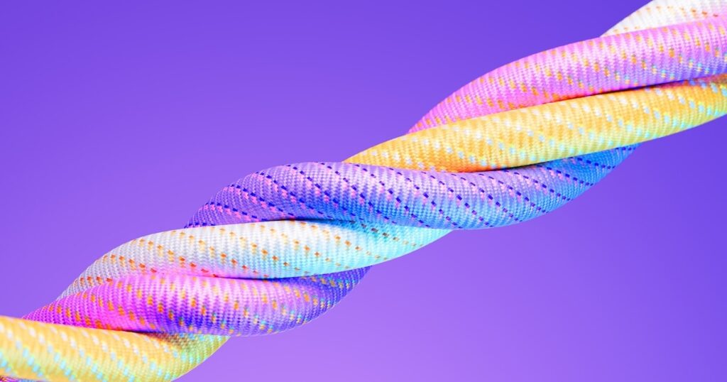 Colorful paracords on purple background. Horizontal composition. Unity concept.