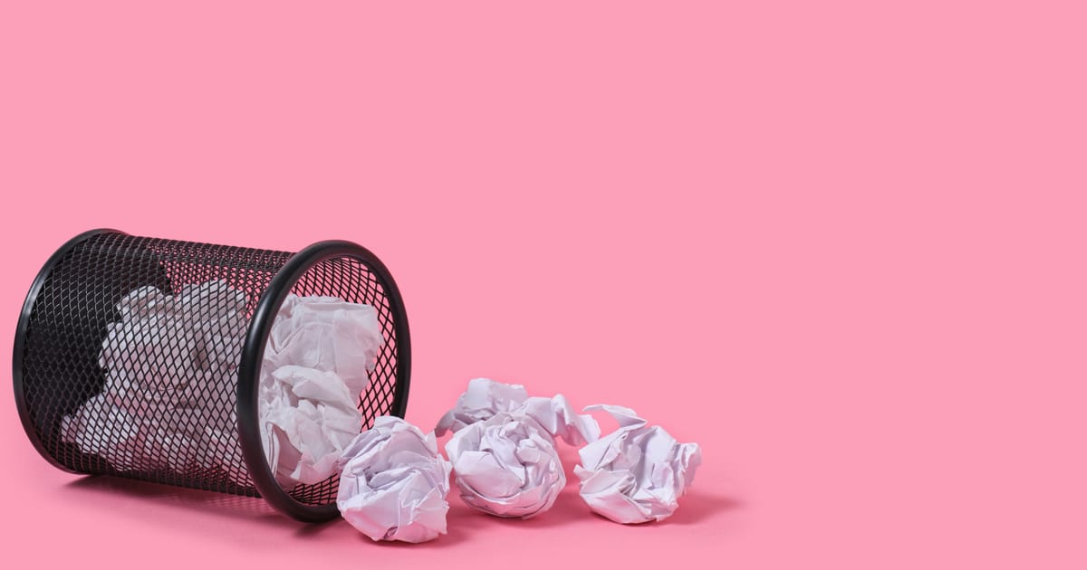 Rashes of crumpled paper from trash can, on pink background