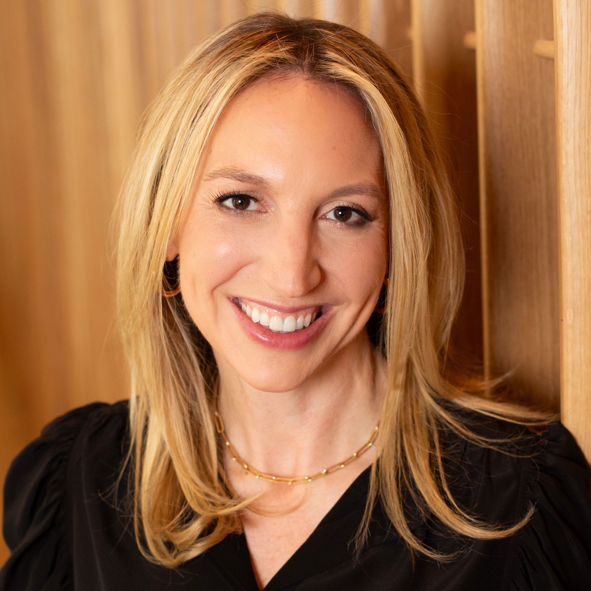 Smiling woman with blonde hair and black shirt