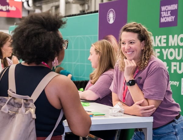 Women networking at a financial event table.