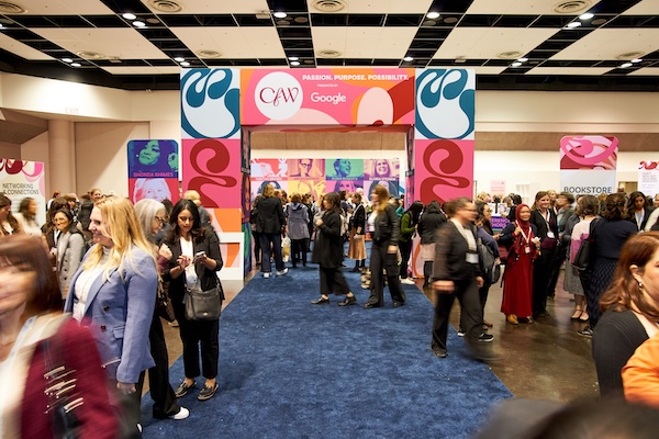 Crowd at tech conference entrance with colorful signage.