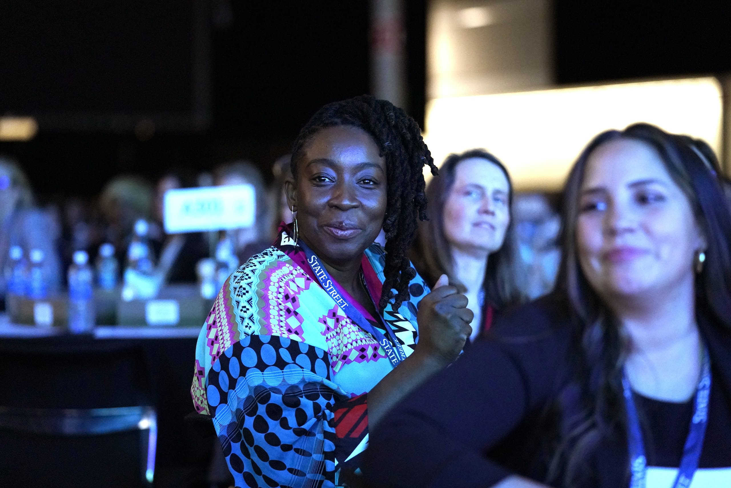 Smiling women at a conference event.