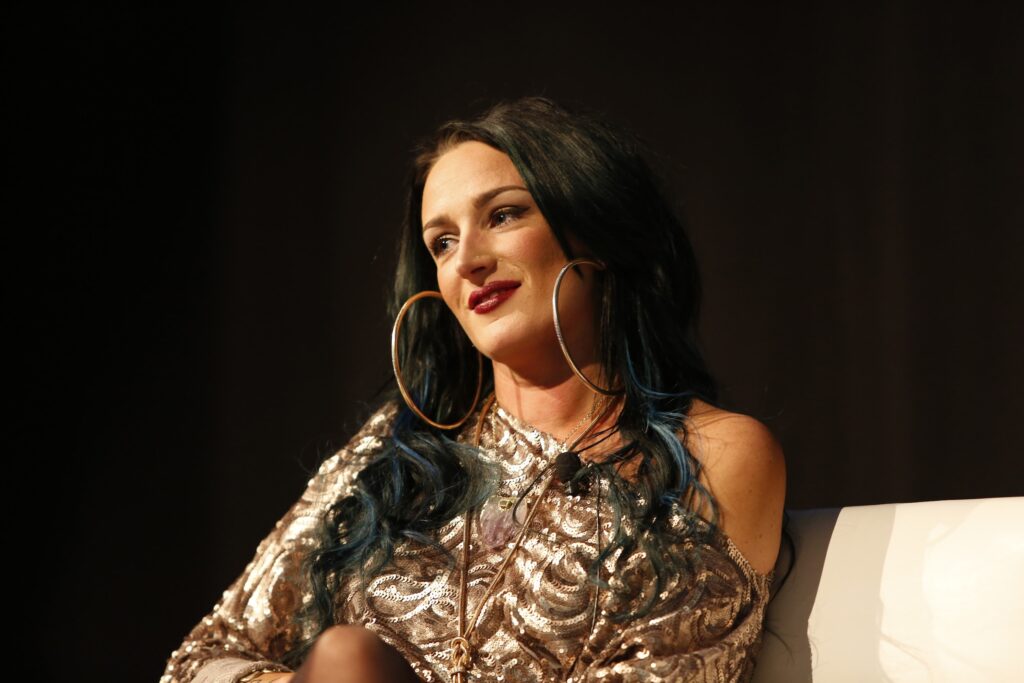 Smiling woman with large hoop earrings on stage.