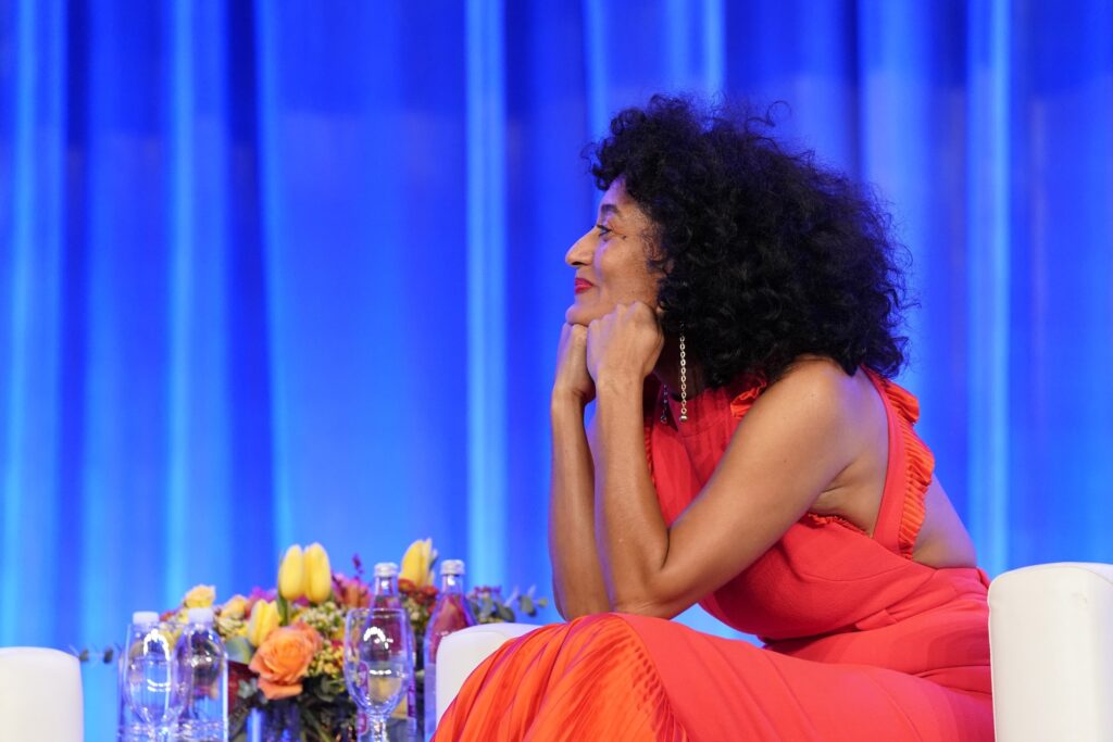 Woman in red dress at event with flowers.