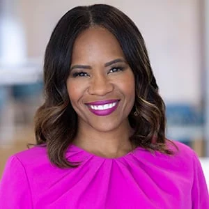 Smiling woman wearing bright pink blouse indoors