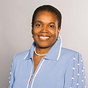 Smiling woman in blue jacket against gray background