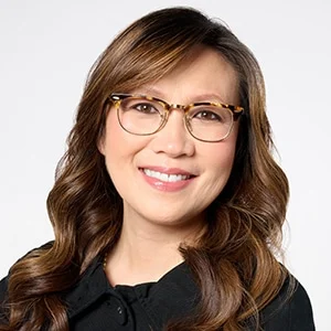 Smiling woman with glasses and wavy brown hair